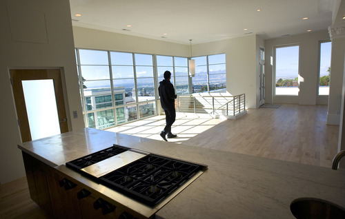 Al Hartmann  |  The Salt Lake Tribune
Realtor Michael Budge walks through the living room/kitchen of a Maple Heights condominium with a view of the city. Beverly Hills-based Kennedy Wilson will auction two high-end condos at Maple Heights at 678 H St. in Salt Lake City. The Maple Heights units range from 4,086 to 4,588 square feet of living space and were previously priced at $2.1 million to $2.4 million. Starting bids are $700,000 and $750,000, respectively.