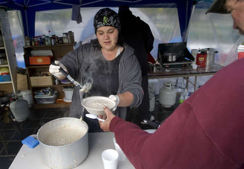 Al Hartmann  |  The Salt Lake Tribune
Volunteer Renae Allen serves hot otameal in the food tent to a member of the Occupy Salt Lake camp in Pioneer Park early Thursday.    She has been a member of the camp for about two weeks.