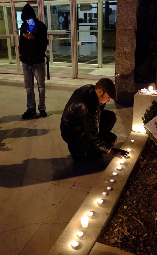 Trent Nelson  |  The Salt Lake Tribune
Justin Kramer lights candles in front of the Public Safety Building in Salt Lake City on Wednesday, Oct. 26, 2011. About two dozen protesters with Occupy Salt Lake marched from Pioneer Park to the Public Safety Building. They lit candles to show appreciation for the Salt Lake City police, but to protest the actions of the police in Oakland, Calif.