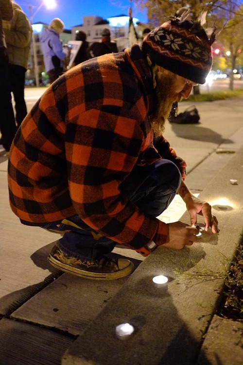 Trent Nelson  |  The Salt Lake Tribune
Braden Jordan lights candles in front of the Public Safety Building in Salt Lake City on Wednesday, Oct. 26, 2011. About two dozen protesters with Occupy Salt Lake marched from Pioneer Park to the Public Safety Building. They lit candles to show appreciation for the Salt Lake City police, but to protest the actions of the police in Oakland, Calif.