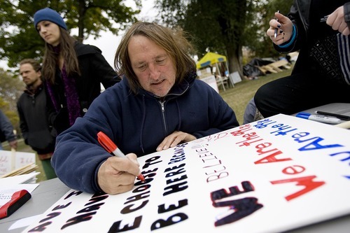 Djamila Grossman  |  The Salt Lake Tribune
Edward Swift draws a sign as he gets ready for a protest against the G20 Summit, at Pioneer Park in Salt Lake City on Saturday.