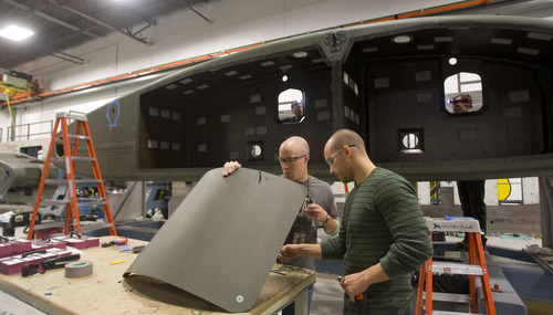 Al Hartmann  |  The Salt Lake Tribune 
Tyler Bo, left , and Justin McBride, work on a door to a helicopter sponson at the ITT Exelis carbon -composite manufacturing facility at the International Center in Salt Lake City.  The sponson holds the fuel tank and landing gear for helicopters.