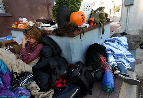 Leah Hogsten | The Salt Lake Tribune  
Occupy SLC protesters Noel Song (left) and Steven Rheuark (feet under blanket) catch up on their sleep while the sun is still warming them Friday, October 28 2011 outside the Federal Reserve Bank on State Street.