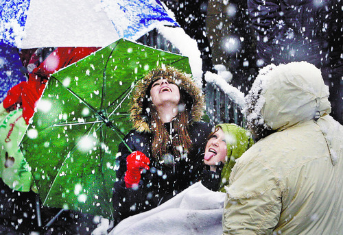 Scott Sommerdorf  |  The Salt Lake Tribune             
Samantha Marie, left, and Ally Burch from Layton try to catch snowflakes on their tongues as they wait at The Rail Event Center for free tickets to a Nov. 11 