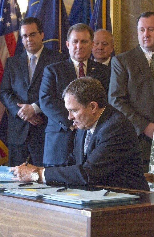 PAUL FRAUGHTON  |  Tribune File Photo
With religious, community, business and government leaders behind him, Utah Gov. Gary Herbert on March 15 signed legislation that grew out of the Utah Compact statement of principles. The bills included a controversial guest-worker program (HB116) and an enforcement bill (HB497).