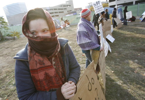 Francisco Kjolseth  |  The Salt Lake Tribune
Sarah Witham tries to keep warm from the cold as she joins a small group of Occupy SLC protesters who remained camped on a privately owned vacant lot in downtown Salt Lake City on Tuesday, November 8, 2011, across from the Federal Reserve Bank at 147 S State Street. It was expected that they would be removed by police after being warned on Monday but as of Tuesday morning the police were in a 