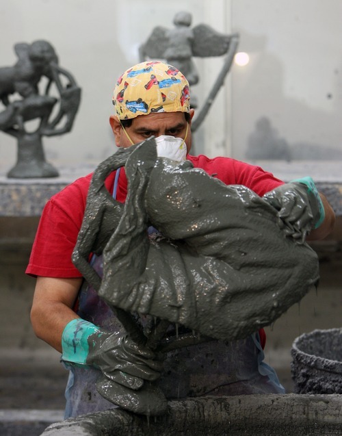 Steve Griffin  |  The Salt Lake Tribune

Salvador Ortiz dips a piece of the sculpture at Adonis Bronze.