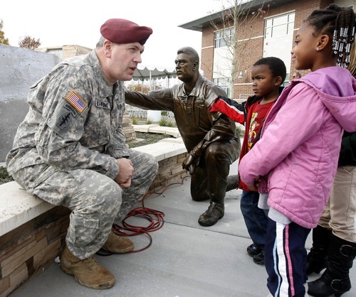 Rick Egan  | The Salt Lake Tribune 
Dan Nehring talks with Elijah Nicoll, 4, and Kayla Nicoll, 6, after the 3rd annual Veterans Day celebration in Taylorsville on Friday. Nehring was the model for the statue sculpted by Brad Taggart of Ephriam.