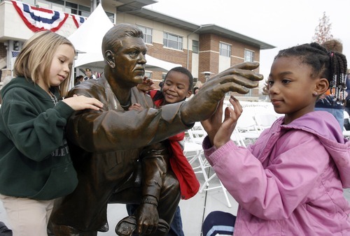 Rick Egan  | The Salt Lake Tribune 

 McKenzie Whitaker,7 (left) Elijah Nicoll,4,  and Kayla Nicoll, 6, (right) examine the statue of a soldier, after the 3rd annual Veterans Day Celebration, in Taylorsville , Friday, November 11, 2011. The statue was sculpted by Brad Taggart of Ephriam,