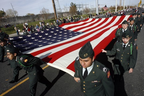 Rick Egan  | The Salt Lake Tribune 
ROTC members carry a 20-by-38-foot garrison flag in the Veterans Day Parade in Taylorsville on Friday. Utah veterans were saluted around the state.