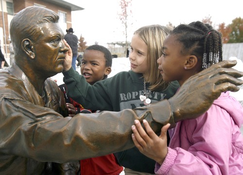 Rick Egan  | The Salt Lake Tribune 
Elijah Nicoll, 4, left, McKenzie Whitaker, 7, and Kayla Nicoll, 6, examine a new bronze statue of National Guard Sgt. Dan Nehring after the 3rd annual Veterans Day Celebration in Taylorsville. The statue, which was sculpted by Brad Taggart, of Ephriam, is the first of nine figures that will be part of the Veterans Memorial at Taylorsville City Hall.