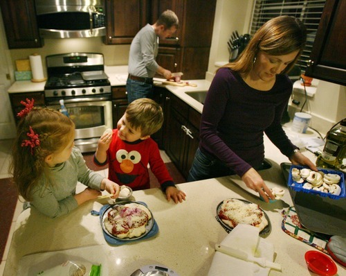 Steve Griffin  |  The Salt Lake Tribune
Amy Brian Oliver helps their children Claire, 4, and Seth, 2, make their pizzas during dinner time at their Salt Lake City, Utah home Wednesday, Nov. 9. After Claire and Seth were diagnosed as infants with a rare metabolic disorder, Amy and Brian started the nonprofit Intermountain PKU and Allied Disorders Association to raise money for research and offer support to other families. The children can eat only 7 grams of protein per day. Their diet is limited to fruits, vegetables, a medical formula and low-protein breads. Amy measures every bite of food they eat.