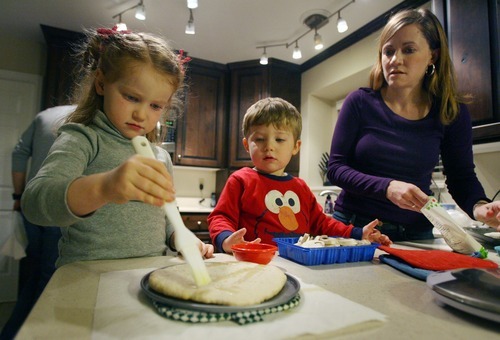 Steve Griffin  |  The Salt Lake Tribune
Amy Oliver helps her children Claire, 4, and Seth, 2, make pizzas during dinner time at their Salt Lake City. After Claire and Seth were diagnosed as infants with a rare metabolic disorder, Amy and Brian Oliver started the nonprofit Intermountain PKU and Allied Disorders Association to raise money for research and offer support to other families. The children can eat only 7 grams of protein per day. Their diet is limited to fruits, vegetables, a medical formula and low-protein breads. Amy measures every bite of food they eat.