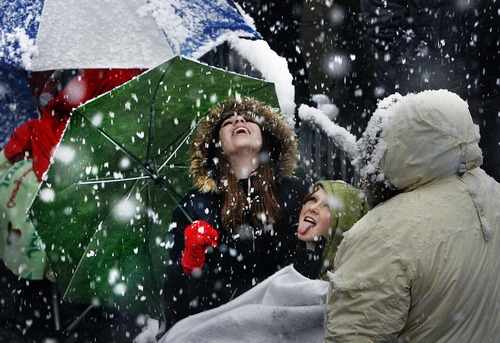 Scott Sommerdorf | The Salt Lake Tribune
Samantha Marie, left, and Ally Burch from Layton try to catch snowflakes on their tongues Saturday as they wait in line at The Rail Event Center for free tickets to a Nov. 11 
