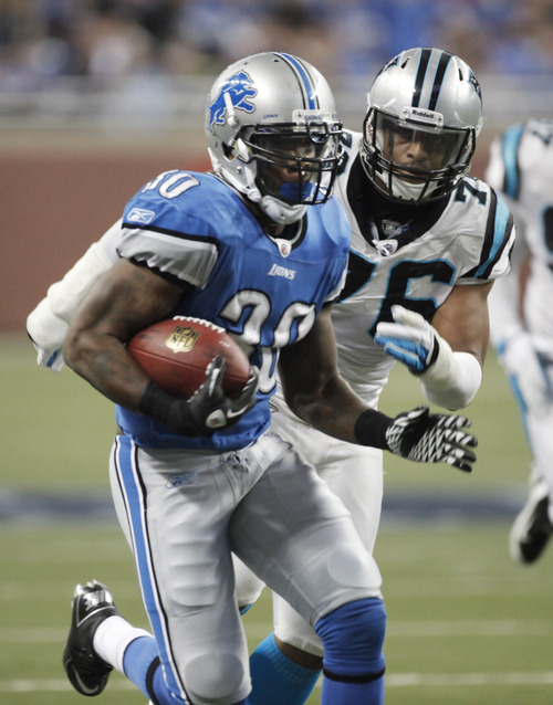 Detroit Lions running back Kevin Smith (30) is pursued by Carolina Panthers defensive end Greg Hardy (76) on his 28-yard touchdown run in the second quarter an NFL football game Sunday, Nov. 20, 2011, in Detroit. (AP Photo/Duane Burleson)