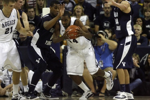 Chris Detrick  |  The Salt Lake Tribune
Utah State Aggies forward Kyisean Reed (34) is guarded by Brigham Young Cougars forward Brandon Davies (0) and Brigham Young Cougars forward Noah Hartsock (34) during the first half of the game at the Dee Glen Smith Spectrum Friday November 11, 2011. Utah State won the game 69-62.