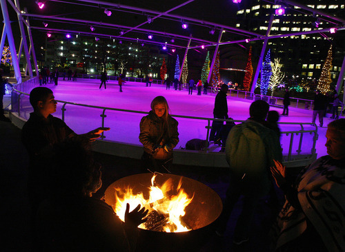 Scott Sommerdorf  |  The Salt Lake Tribune             
Skaters and visitors warm their hands at one of the large open fire pit at the re-opening of the Gallivan ice rink on Nov. 18, 2011.