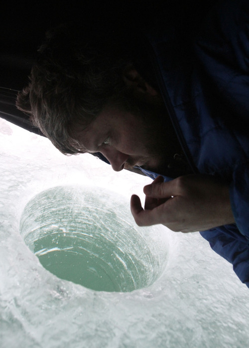 Francisco Kjolseth  |  The Salt Lake Tribune
Outdoor writer for the Salt Lake Tribune Brett Prettyman eyes the bottom of Fish Lake as he sees interested fish strike his line while taking refuge inside a shelter during an ice fishing trip on Tuesday, Feb. 15, 2011.