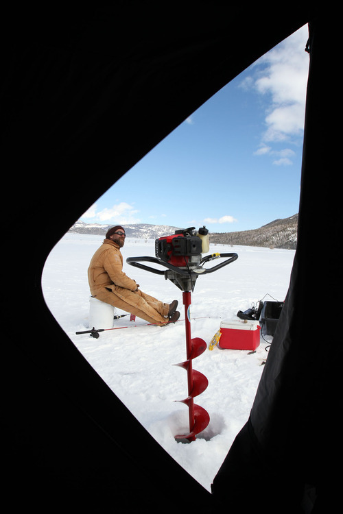 Francisco Kjolseth  |  The Salt Lake Tribune
Seen through an ice shelter, Richard Hepworth, Southern Region DWR Aquatics Biologist, keeps an eye on the fast-moving clouds as a storm moves in over Fish Lake in Sevier County on Wednesday, Feb. 16, 2011.