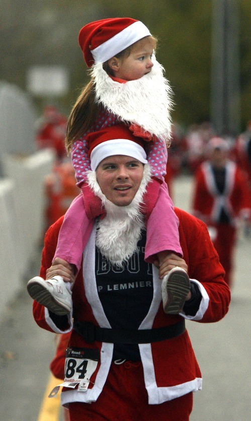 Rick Egan  | The Salt Lake Tribune 
Kyle Strate carries 4-year-old Lacey Strate during West Valley City's Santa Run 5K at Valley Fair Mall on Friday.