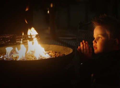 Rick Egan  | The Salt Lake Tribune 
Three-year-old Bryton Roper, of Provo, warms his hands by the fire at the Christmas Village in Ogden on Saturday. The village has been a tradition in Ogden since 1962.