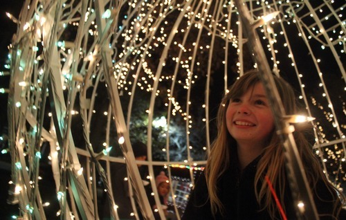 Rick Egan  | The Salt Lake Tribune 

9-year-old Corinne Whaley, Ogden, sites inside a giant Christmas ornament, in  the Christmas Village, in the Municipal Gardens in Ogden, the lights were tired on after the annual Holiday Electric Light Parade on Washington Boulevard, Saturday, November 26, 2011.