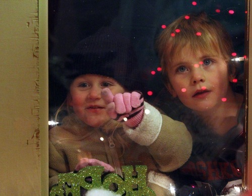 Rick Egan  | The Salt Lake Tribune 

Cora Miller, 3, and Carter Jeppsen, 4, peer through window of a cottage in the Christmas Village in Ogden on Saturday. Santa flipped the switch to turn on the Christmas Village lights after the annual Holiday Electric Light Parade on Washington Boulevard Saturday evening.