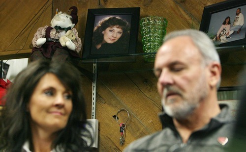 Steve Griffin  |  The Salt Lake Tribune

A portrait of Sherry Black sits on a shelf at B&W Billiards and Books store in Salt Lake City on Monday, Nov. 28, 2011, as Heidi Miller and her father, Earl Black, talk with the media from the bookstore where Sherry was murdered one year ago. Sherry was Heidi's mother and Earl's wife. The father and daughter will host a memorial service in memory of Sherry on Wednesday, Nov. 30, 2011, at Wasatch Lawn Memorial Park and Mortuary in Salt Lake City.