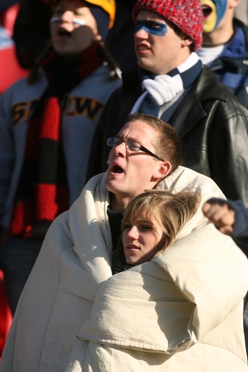 Leah Hogsten | The Salt Lake Tribune  
Snow College students Josh Burt and his girlfriend Hannah Olsen snuggle together in the freezing temperatures during football game at Rio Tinto Stadium. 
Snow College leads at the half 22-9 over Eastern Arizona  during the 8th Annual Top of the Mountain Bowl Saturday, December 3 2011