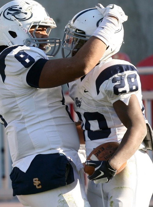 Leah Hogsten | The Salt Lake Tribune  
Snow's Breon Allen, congratulated by Soni Kinikini made three touchdowns during the game.
Snow College defeated Eastern Arizona  36-9 during the 8th Annual Top of the Mountain Bowl Saturday, December 3 2011