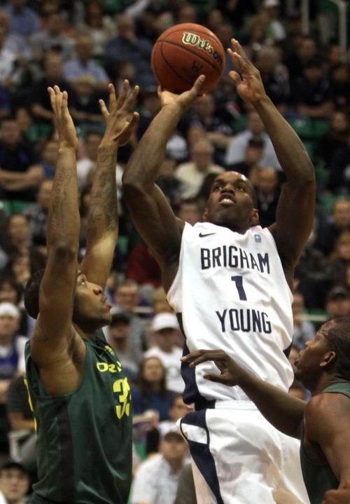 Rick Egan  | The Salt Lake Tribune 

BYU's Charles Abouo (1) talks a shot for the Cougars, as Carlos Emery (33)defends for Oregon, in second half basketball action, BYU vs Oregon, at EnergySolutions Arena, Saturday, December 3, 2011.