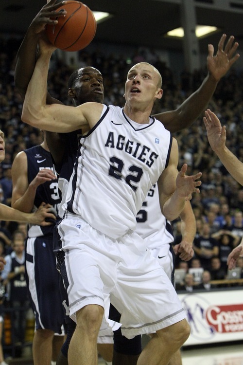 Chris Detrick  |  The Salt Lake Tribune
Utah State Aggies forward Brady Jardine (22) and Brigham Young Cougars guard/forward Charles Abouo (1) go for the ball during the first half of the game at the Dee Glen Smith Spectrum Friday November 11, 2011. Utah State won the game 69-62.