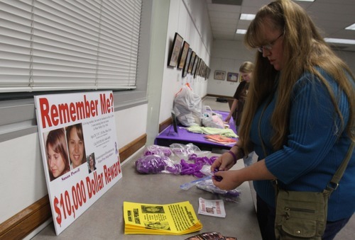 Rick Egan  | The Salt Lake Tribune 

Kiirsi Helliwell arranges purple ribbons and bracelets on a table at the Hunter Library in West Valley City on Monday. Friends and family of missing West Valley City woman Susan Cox Powell gathered donations for the Christmas Box House.