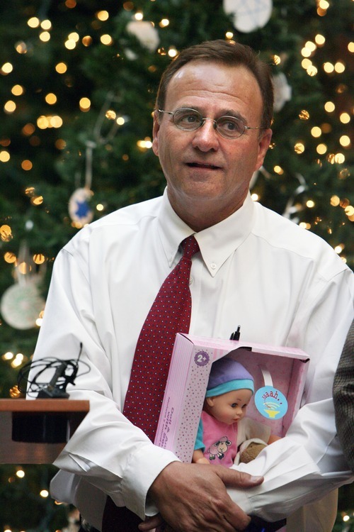 Steve Griffin  |  The Salt Lake Tribune

Salt Lake County Councilman Max Burdick holds a doll as Salt Lake County Mayor Peter Corroon  and other Salt Lake County elected officials placed presents under Christmas trees at the Salt Lake County Government Center on Tuesday, December 6, 2011, kicking off a drive to collect Christmas gifts for children in the county's Youth Services and Shelter programs.