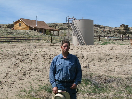 FILE - This May 22, 2009 picture shows John Fenton, a farmer who lives near Pavillion in central Wyoming, near a tank used in natural gas extraction, in background. Fenton and some of his neighbors blame hydraulic fracturing, or 