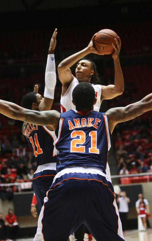 Kim Raff | The Salt Lake Tribune
Utah's Dijon Farr goes up for a shot while being defended by Cal State-Fullerton's D.J. Seeley, left, and Omondi Amoke at the Huntsman Center on Wednesday.