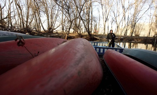 Leah Hogsten | The Salt Lake Tribune  
Jason Bosen, who works at CLAS Ropes Course, cleans out one of the 40-person boats the company uses during its winter Provo River winter cruises on Thursday. Bosen's employer, Ben Allen, is protesting plans to divert the Provo River a half-mile north of his property to create a delta that would be more conducive to breeding for June suckers, an endangered fish.