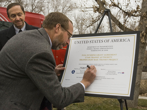 Paul Fraughton | The Salt Lake Tribune
With Draper Mayor Darrell Smith looking on, Federal Transit Administrator Peter M. Rogoff signs the document providing full funding for the 3.8 mile extension of the Trax Blue line which will end at Pioneer Road near 1300 East in Draper.