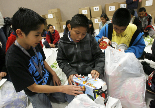 Francisco Kjolseth  |  The Salt Lake Tribune
Lincoln Elementary school fifth-graders Ivan Oliva, 10, Mario Hernandez, 11, and Adrian Garcia, 11, from left, check out one another's presents on Thursday. Lincoln Elementary School has one of the highest percentages of children  living below the poverty line. Without gifts from the Salt Lake Community and Utah Central Credit Union, these children would not have Christmas.