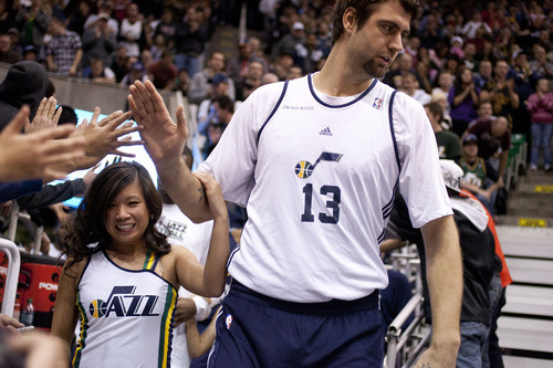 Jeremy Harmon  |  The Salt Lake Tribune

Utah's Mehmet Okur is escorted onto the court by one of the Jazz dancers prior to a scrimmage at EnergySolutions Arena in Salt Lake City, Saturday, Dec. 17, 2011.