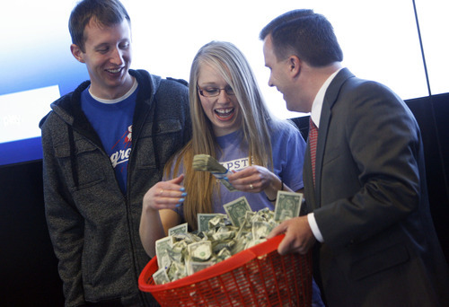 Francisco Kjolseth  |  The Salt Lake Tribune
Nathan Thompson gets to be a part of the festivities as his wife Lori Thompson, a student at Utah State University, is presented with $10,000 in cash by Rob Brough, executive vice president at Zions Bank after she beat out nine other contestants in seven budgeting challenges, such as Dumpster diving, to be crowned the 