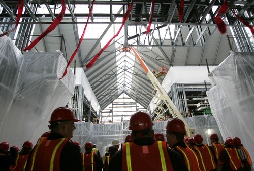 Kim Raff | The Salt Lake Tribune
People watch during a ceremony at the outdoors store Scheels as the store leader, Karen Jones, puts the last bolt in the exterior steel structure completing the steel framework for the store in Sandy, Utah on December 21, 2011.   The store uses 4 million pounds of structural steel and the store is expected to open in October 6, 2012.