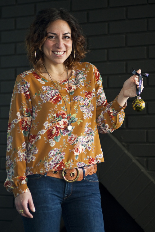 Chris Detrick  |  The Salt Lake Tribune
Marian Rivkind, 32, poses for a portrait with a Yölka Chocolate ornament Friday December 23, 2011. Yölka are rich Belgian chocolate ornaments wrapped in black, silver and gold foil and hanging on ribbons. They are a touch of opulence that were inspired by her Russian mother and something similar she would do when Marian was a child.