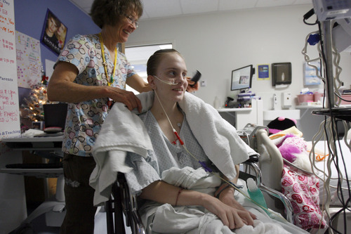 Francisco Kjolseth  |  The Salt Lake Tribune
Nurse Jennifer Russell finishes giving Megan Birk, 18, a French braid at Primary Children's Medical Center on Wednesday, December 14, 2011. Megan has survived innumerable impossible medical hurdles. From being born severely premature to leukemia to a heart transplant to a recent bout with tumors. Her mother considers her an angel, filled with good, determined to survive.