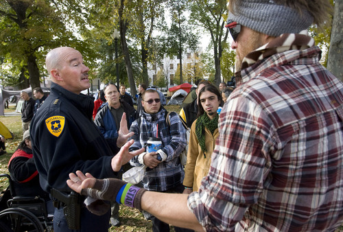 Al Hartmann  |  The Salt Lake Tribune
Salt Lake City Police Chief Chris Burbank, left,  reasons with members of the Occupy Salt Lake in Pioneer Park Friday afternoon November 11.  He announced to occupiers that the camp would have to be dismantled and vacated by sundown on Saturday due to a death in the camp earlier on Friday morning and public safety concerns.