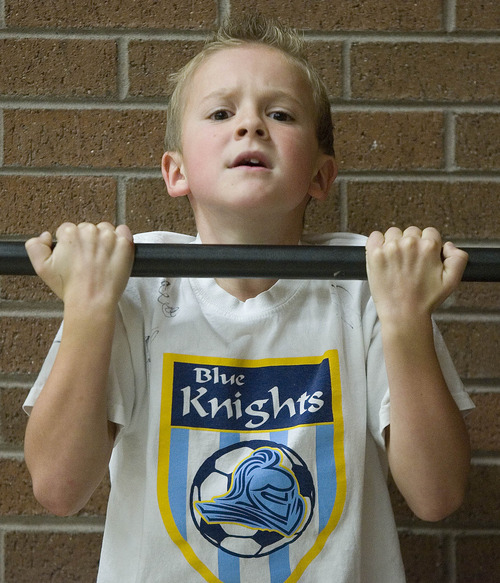 Paul Fraughton | The Salt Lake Tribune
Cannon Reber, a third-grader at Park Lane Elementary School in Sandy, strains as he does his 15th pull-up for  the  President's Challenge fitness test. 
  Friday, December 16, 2011