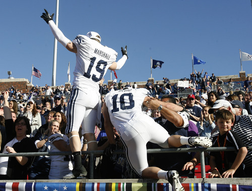Rick Egan  | The Salt Lake Tribune 

Brigham Young Cougars wide receiver Matt Marshall (19)and running back JJ Di Luigi (10) climb into the stands to celebrate the 24-21 win over Tulsa in the Armed Forces Bowl, in Dallas, Texas, Friday, December 30, 2011
