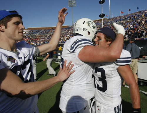 Rick Egan  | The Salt Lake Tribune 

Cougar team mates congratulate Riley Nelson (13),  as they celebrate the 24-21 win over Tulsa in the Armed Forces Bowl, in Dallas, Texas, Friday, December 30, 2011