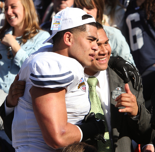Rick Egan  | The Salt Lake Tribune 

Brigham Young Cougars linebacker Uona Kaveinga (4) celebrate the 24-21 win over Tulsa in the Armed Forces Bowl, with Elder Elder Ulukivaiola, from the Dallas Texas Mission, Friday, December 30, 2011