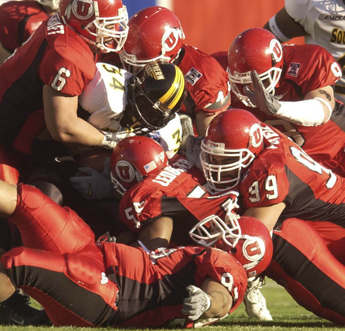 Tribune file photo

 A sea of University of Utah players gang tackle Southern Mississippi's Wayne Hardy during the 45th Annual AXA Liberty Bow in Memphis, TN, December 31, 2003.